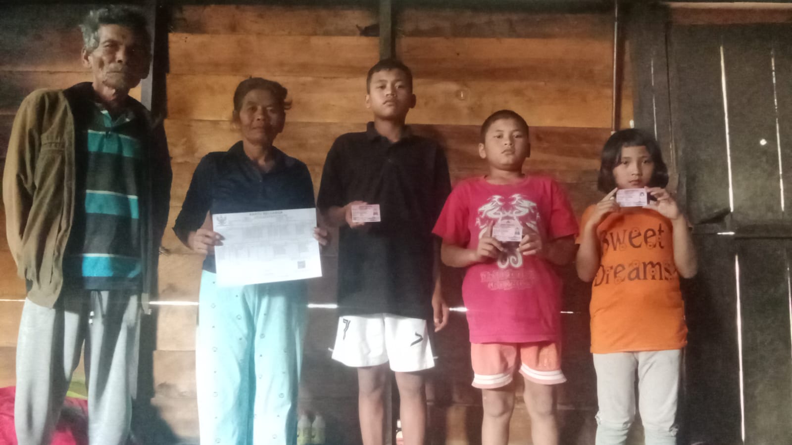 Surti Sagala warga Lae Mbara Desa Parbuluan VI kecamatan Parbuluan bersama cucunya memperlihatkan dokumen Adminduk.(ist)