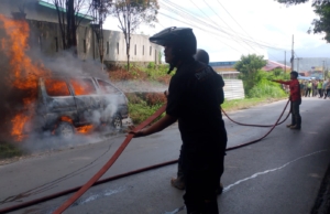 Tim Damkar Dairi lakukan pemadaman terhadap minibus uang terbakar di jalan Sidikalang - Medan, Sitinjo.(ist)