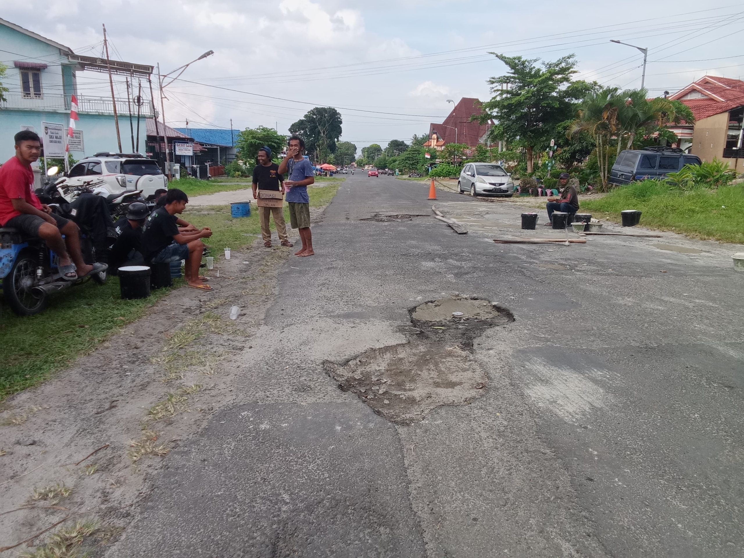 Sejumlah pemuda lapangan bola atas kota Pematangsiantar melakuka perbaikan jalan secara swadaya.(Hegi)