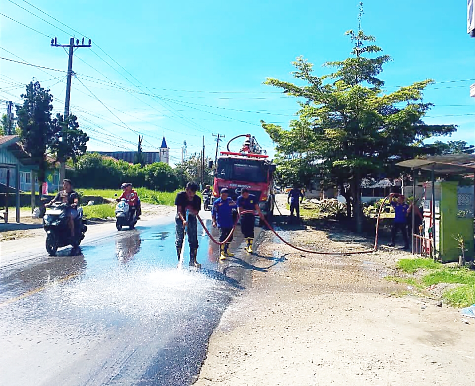 Petugas Damkar bersihkan tumpahan solar di jalan Lintas Sidikalang - Medan Desa Sitinjo II.(ist)