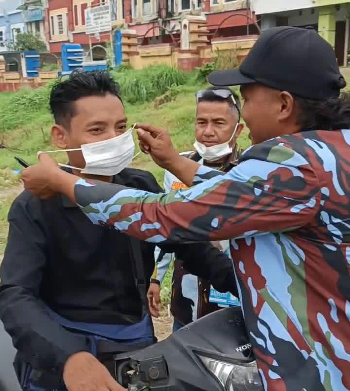 Kader DPP IPK Simalungun Memasangkan Masker ke pengendara.(Hegi)